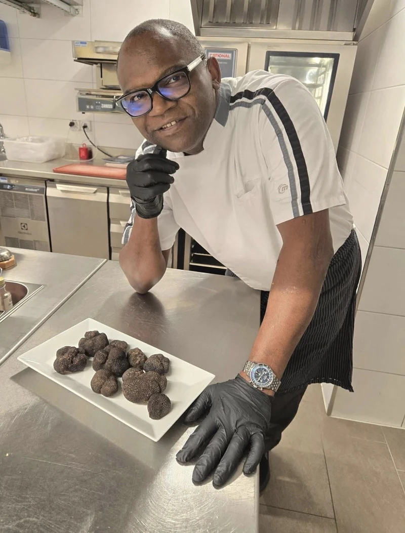 Un cuisinier présente des truffes en cuisine.
